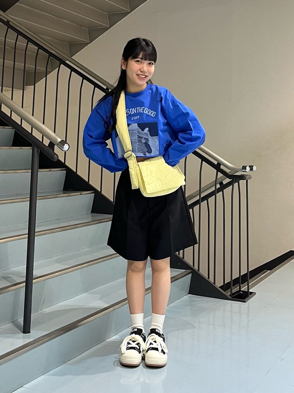 ブラック系のその他パンツ、ブルー系のTシャツ/カットソー、イエロー系のショルダーバッグを着用したレディースの春コーディネートの3枚目の写真