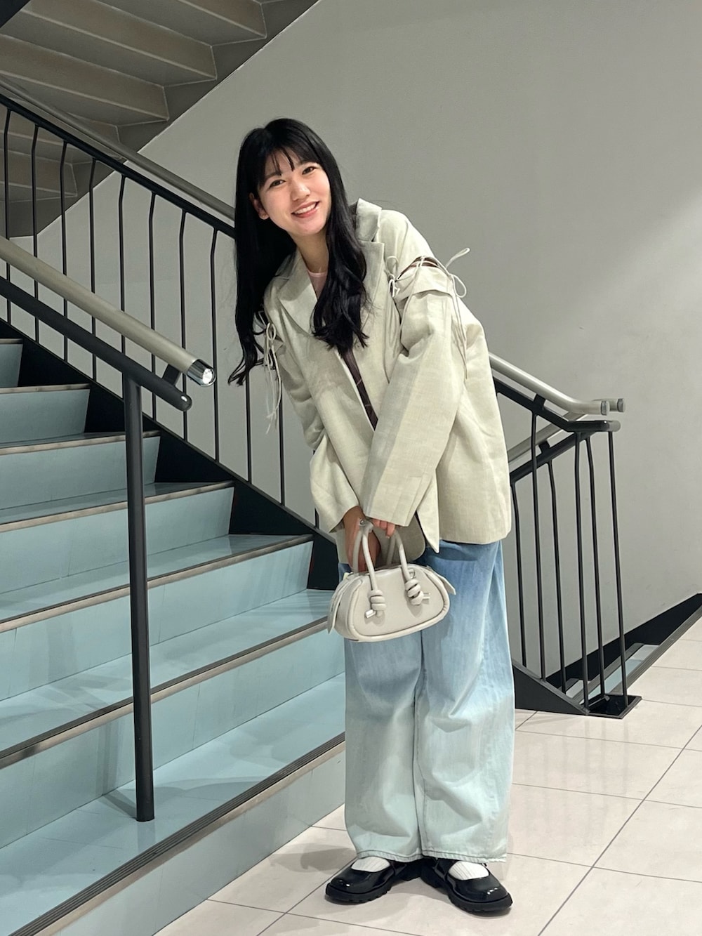 ブルー系のデニムパンツ、グレー系のショルダーバッグ、ピンク系のタンクトップを着用したレディースの春コーディネートの3枚目の写真