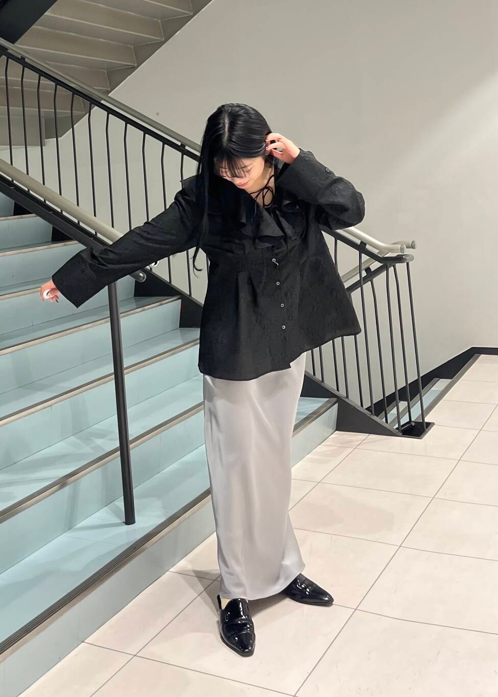 ブラック系のシャツ/ブラウス、グレー系のスカートを着用したレディースの春コーディネートの2枚目の写真