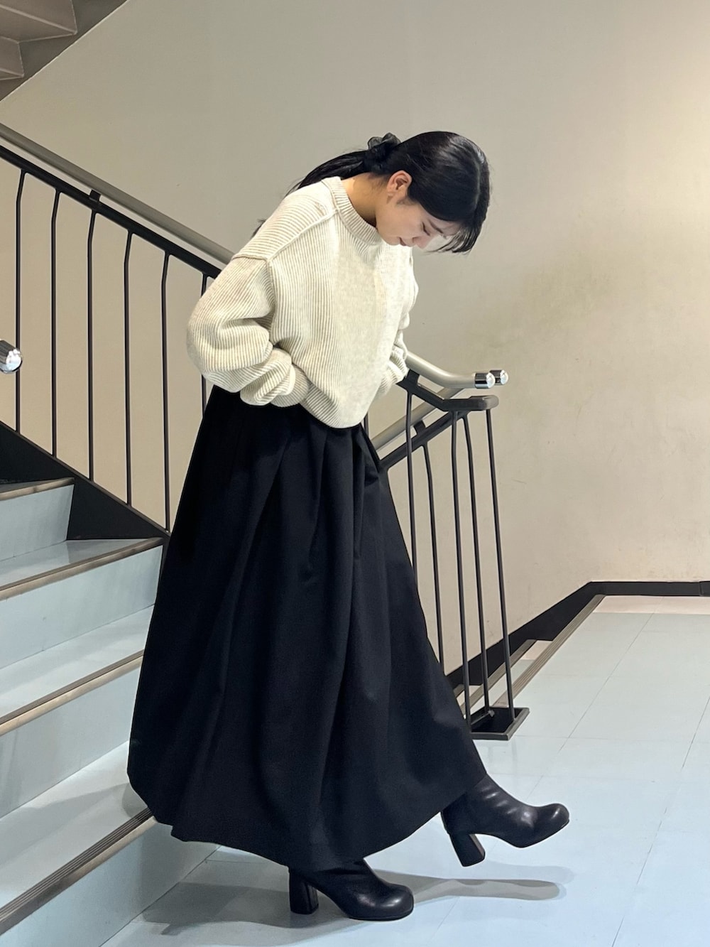 ホワイト系のニット/セーター、ブラック系のワンピース、ブラック系のブーツを着用したレディースの冬コーディネートの2枚目の写真