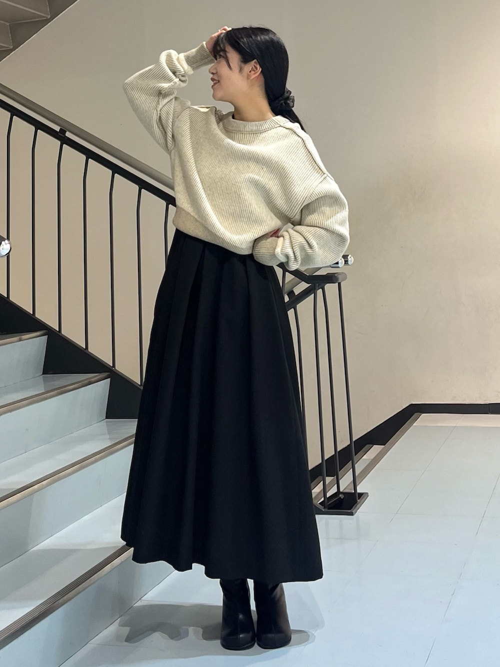 ホワイト系のニット/セーター、ブラック系のワンピース、ブラック系のブーツを着用したレディースの冬コーディネートの3枚目の写真