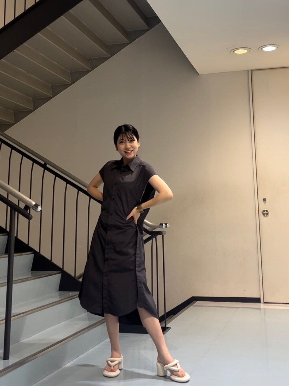ホワイト系のサンダル、グレー系のワンピースを着用したレディースの夏コーディネートの2枚目の写真