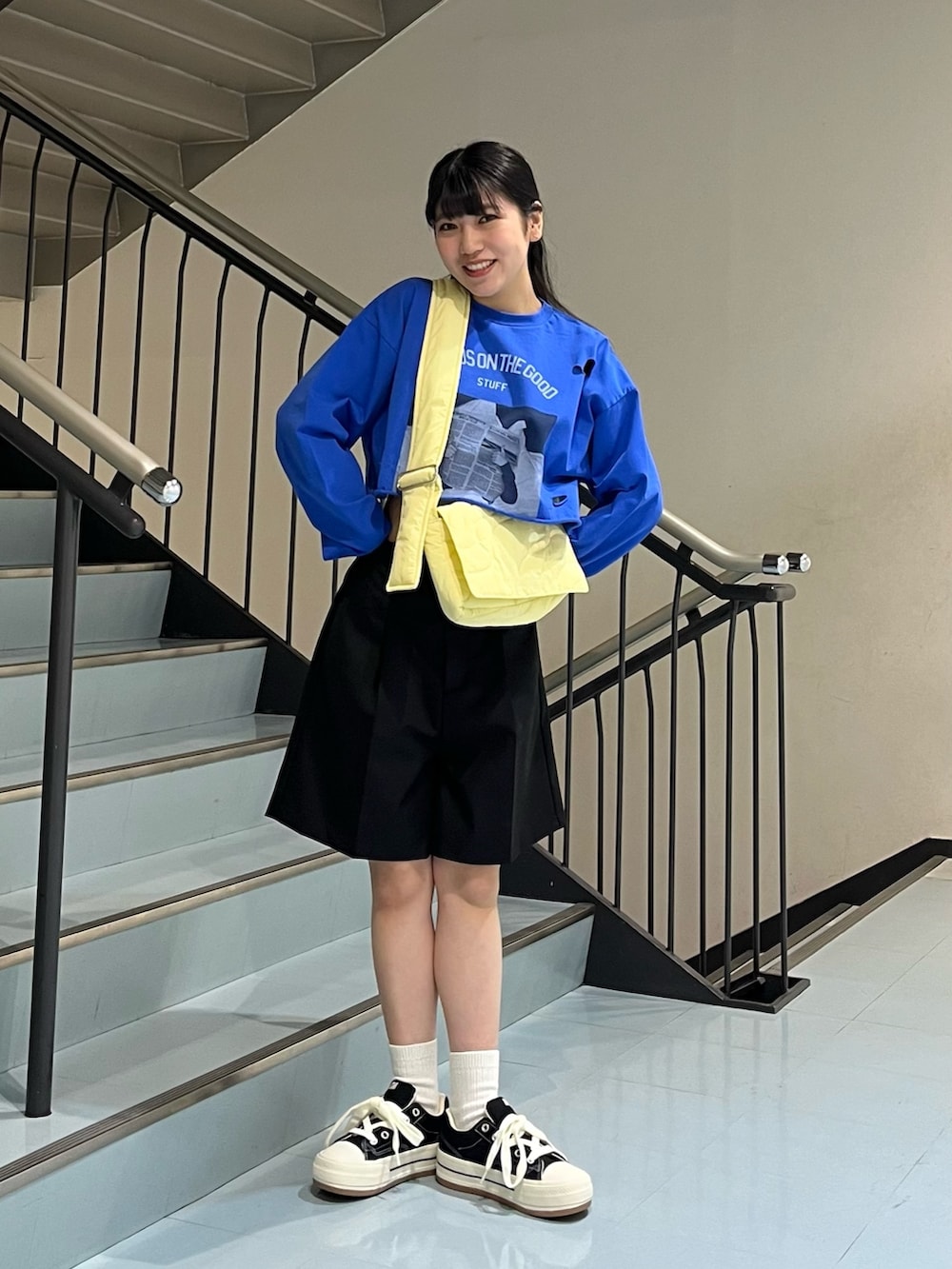 ブラック系のその他パンツ、ブルー系のTシャツ/カットソー、イエロー系のショルダーバッグを着用したレディースの春コーディネートの2枚目の写真