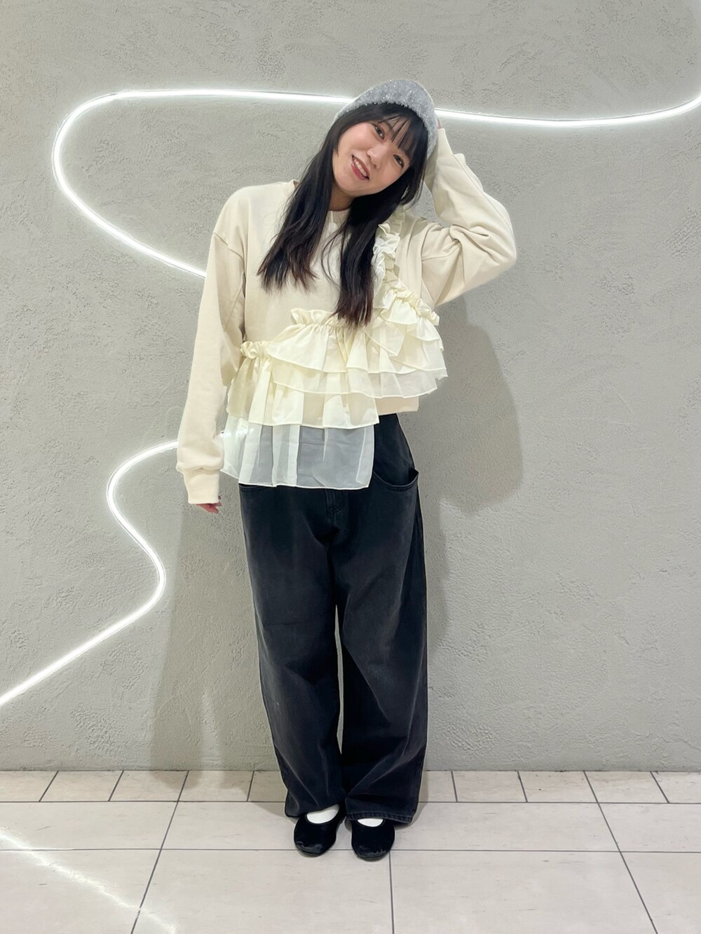 ブラック系のデニムパンツ、ホワイト系のスウェット、シルバー系のニットキャップ/ビーニーを着用したレディースの冬コーディネートの2枚目の写真