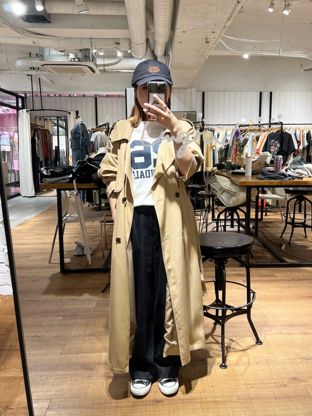 ホワイト系のTシャツ/カットソー、ベージュ系のトレンチコート、グレー系のキャップを着用したレディースの冬コーディネートの2枚目の写真
