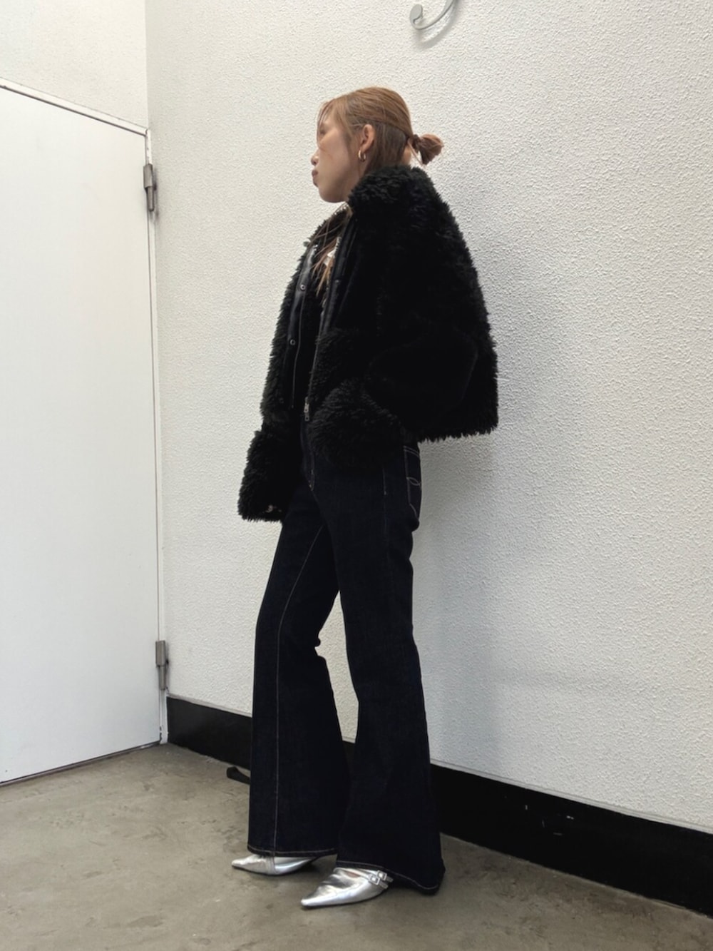 ブラック系のブルゾン、ブルー系のデニムパンツ、シルバー系のパンプスを着用したレディースの秋コーディネートの2枚目の写真