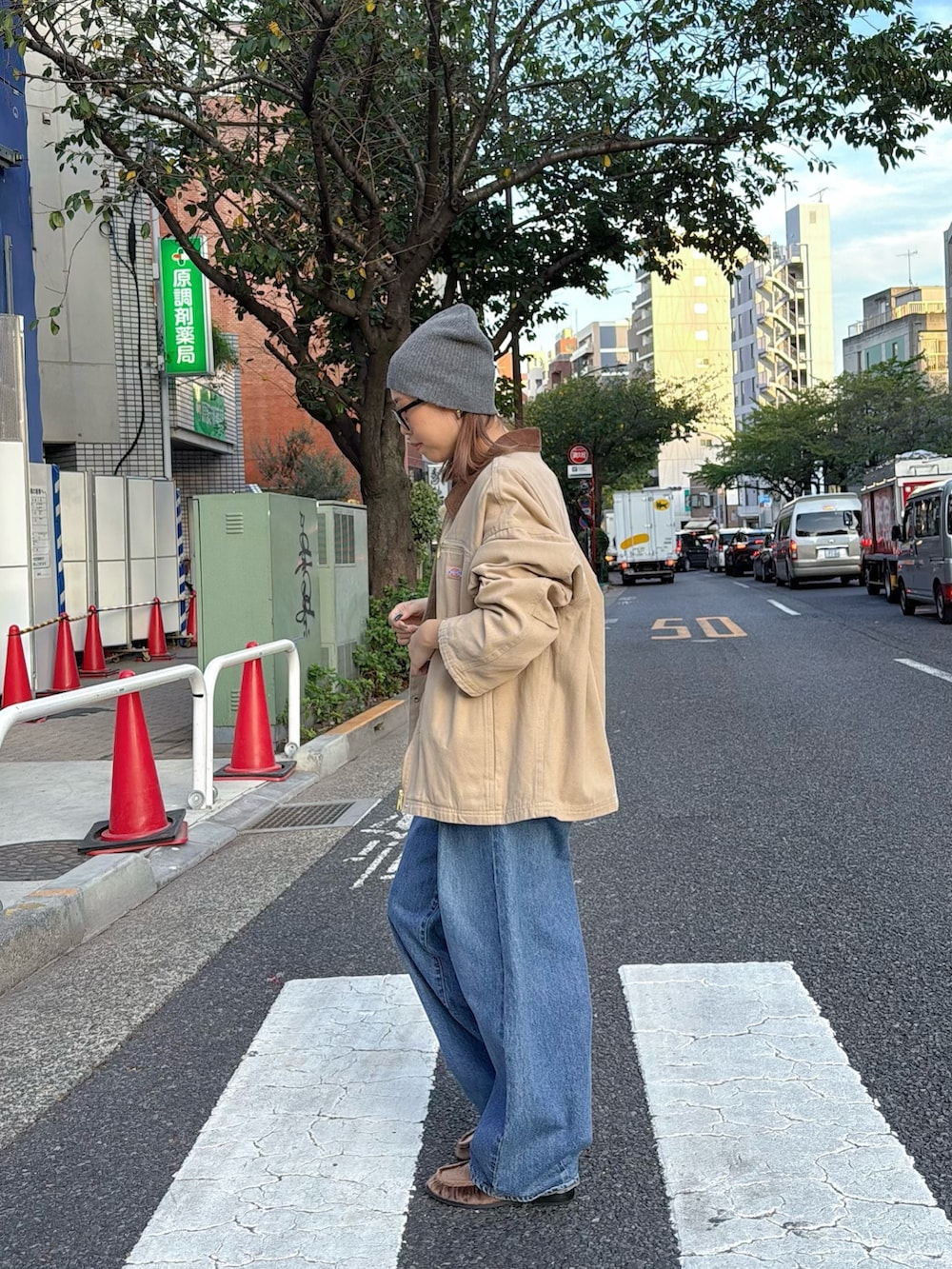 ブルー系のデニムパンツ、ベージュ系のブルゾン、ブラウン系のローファーを着用したレディースの秋コーディネートの2枚目の写真