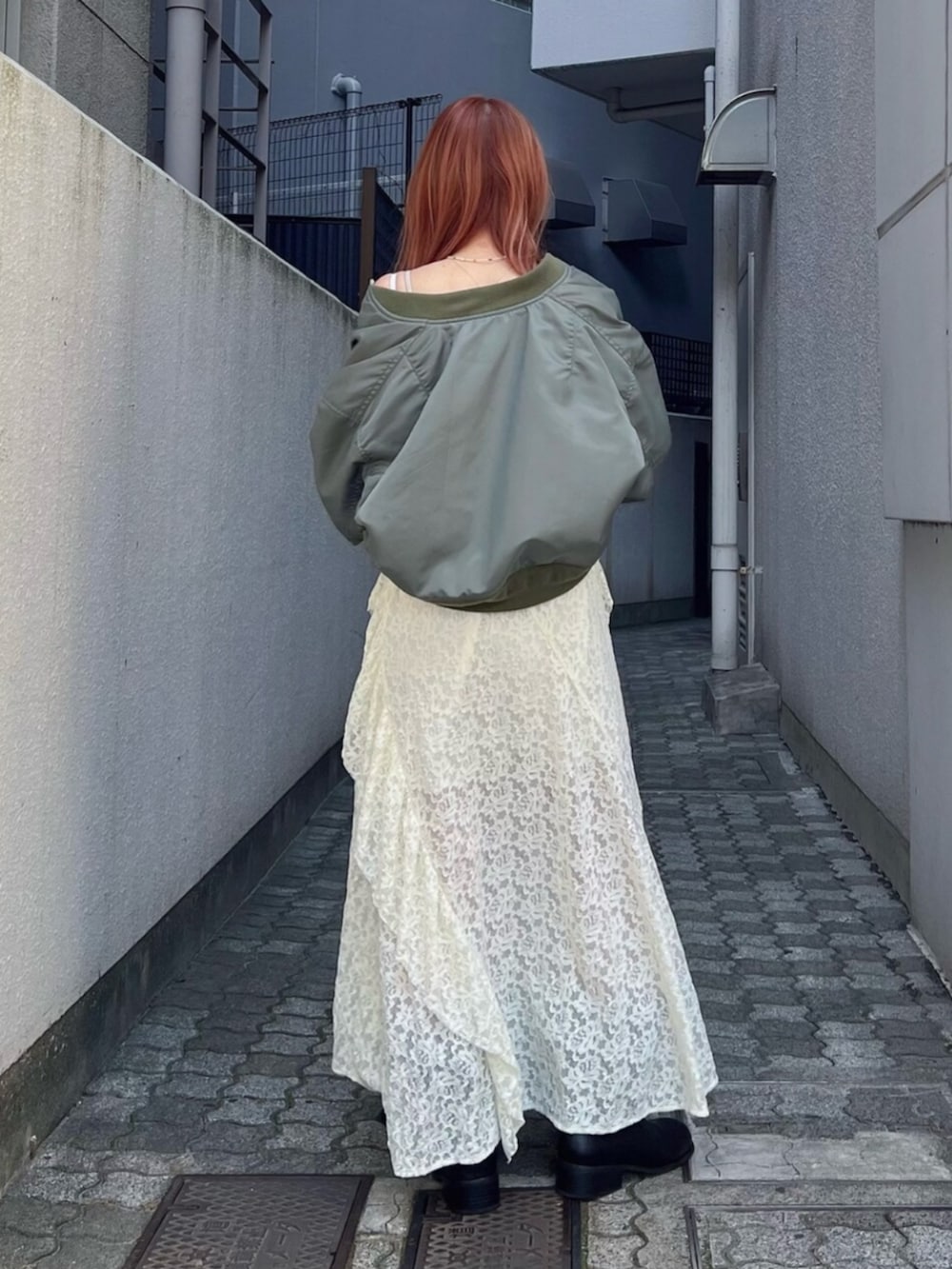 グリーン系のMA-1、ホワイト系のワンピースを着用したレディースの夏コーディネートの2枚目の写真