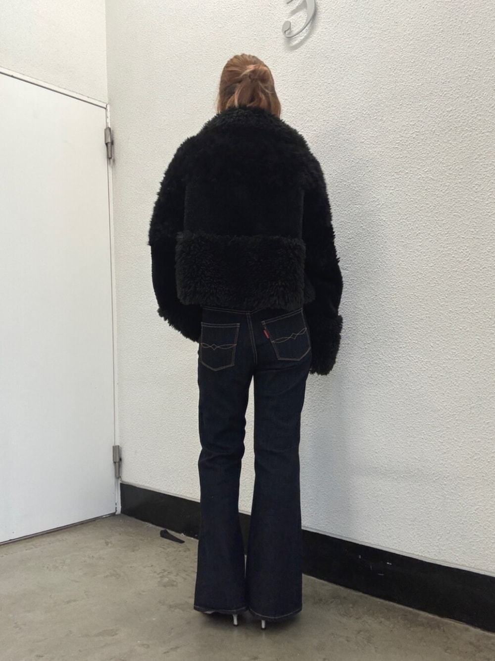 ブラック系のブルゾン、ブルー系のデニムパンツ、シルバー系のパンプスを着用したレディースの秋コーディネートの3枚目の写真