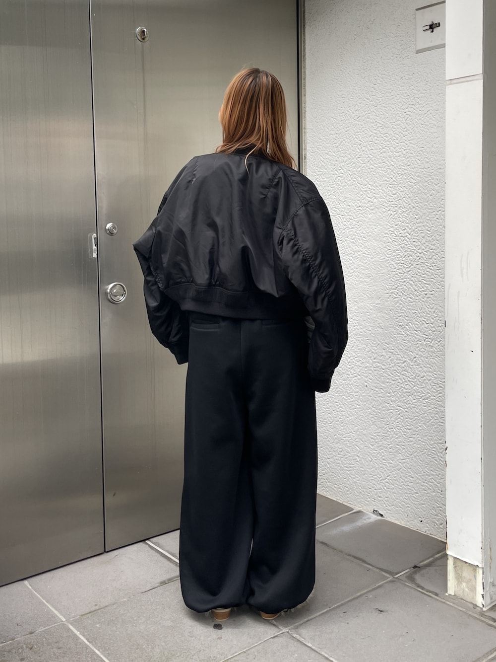 ブラック系のMA-1、グレー系のTシャツ/カットソー、ブラック系のスウェットパンツを着用したレディースの秋コーディネートの3枚目の写真