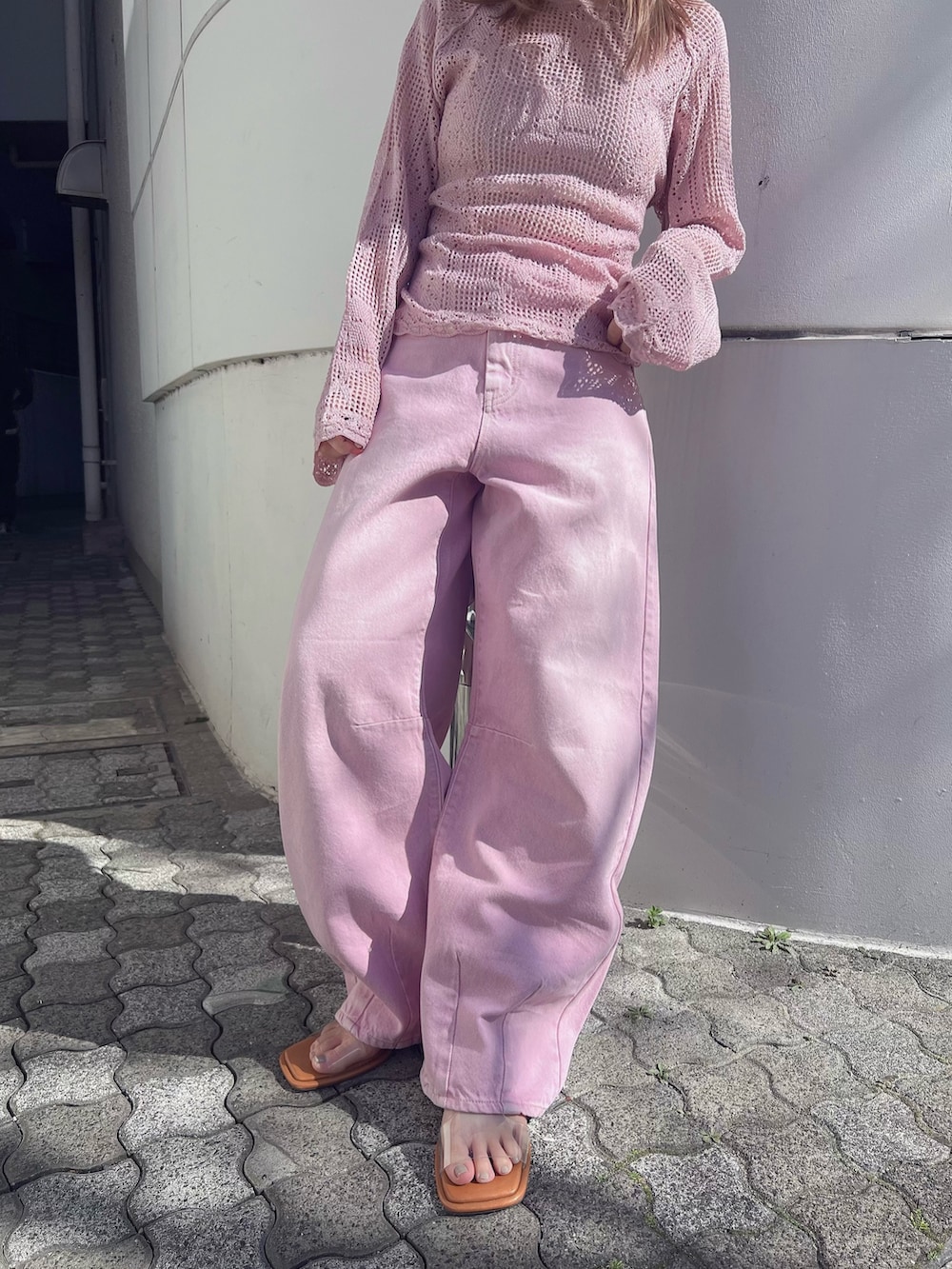 ピンク系のニット/セーター、ピンク系のデニムパンツ、その他のサンダルを着用したレディースの冬コーディネートの2枚目の写真