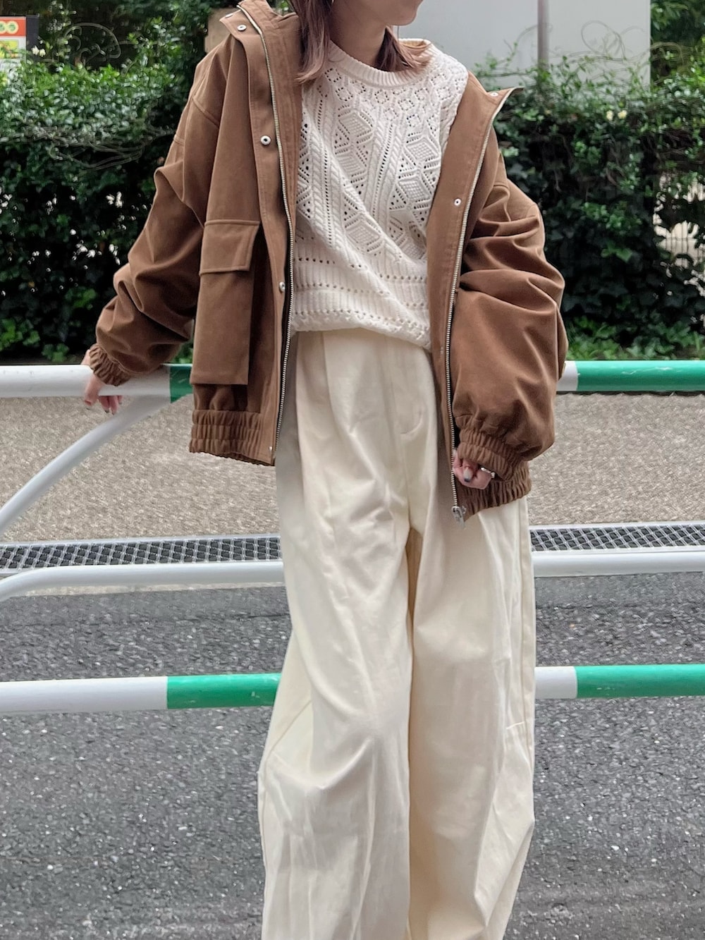 ホワイト系のニット/セーター、ブラウン系のブルゾン、ホワイト系のチノパンツを着用したレディースの秋コーディネートの2枚目の写真