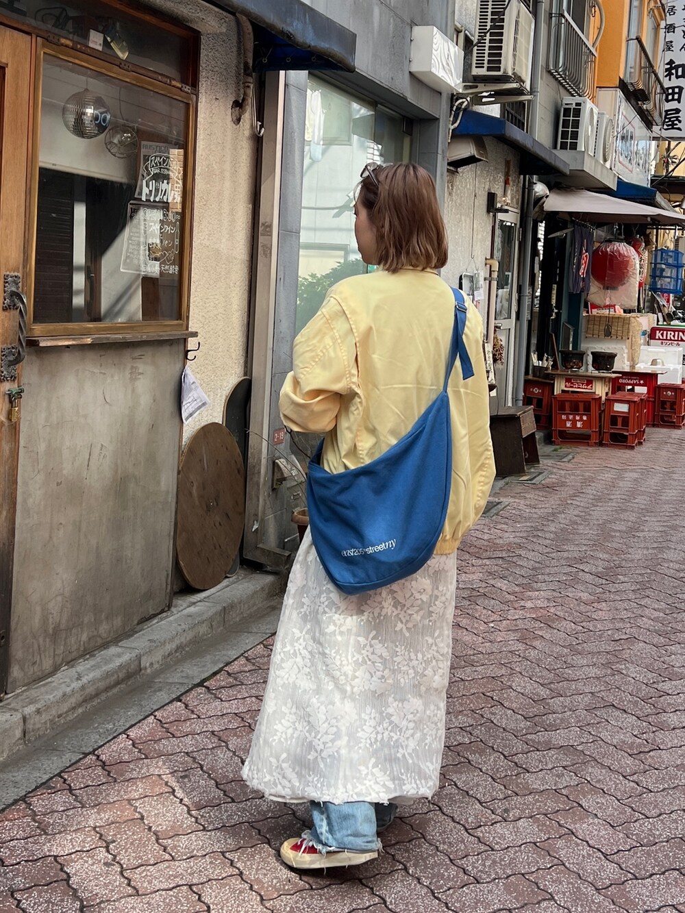 ブルー系のハンドバッグを着用したレディースの春コーディネートの2枚目の写真