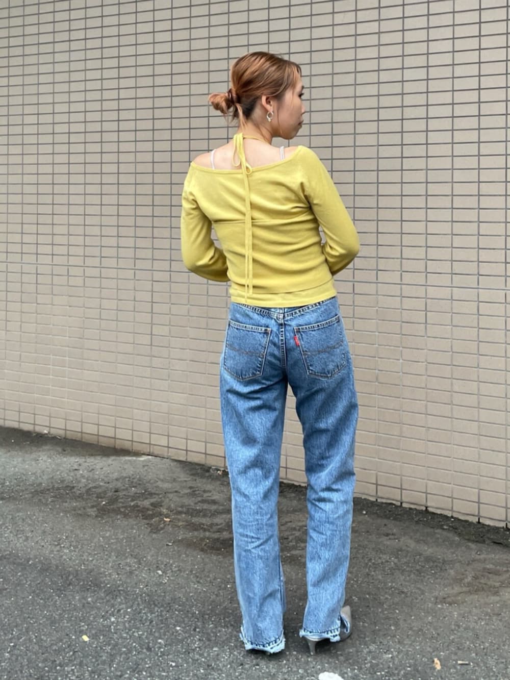 ブルー系のデニムパンツ、イエロー系のニット/セーターを着用したレディースの秋コーディネートの3枚目の写真