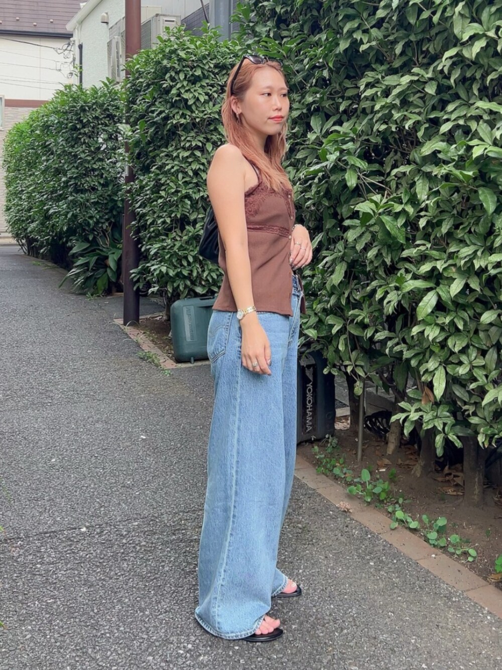ブラウン系のTシャツ/カットソー、ブルー系のデニムパンツを着用したレディースの夏コーディネートの4枚目の写真