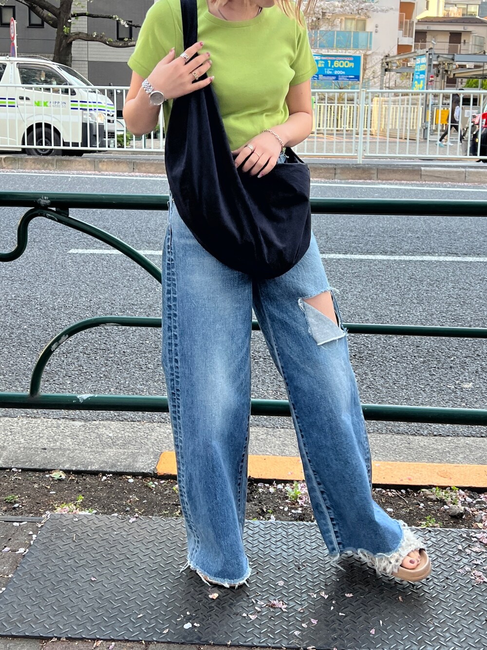 グリーン系のTシャツ/カットソー、ブラック系のショルダーバッグ、ブルー系のデニムパンツを着用したレディースの春コーディネートの2枚目の写真