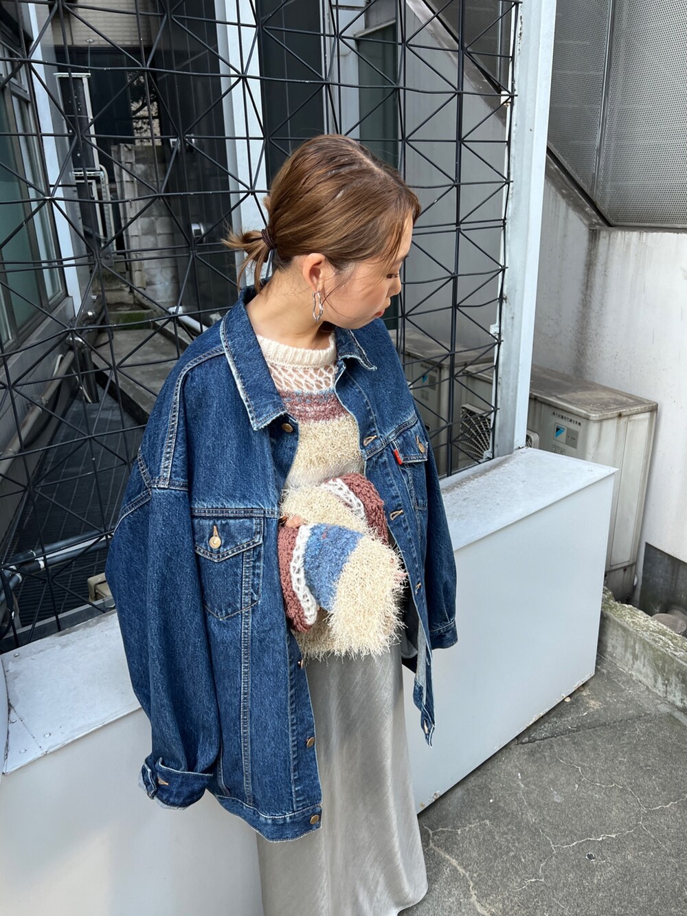 ブルー系のデニムジャケット、グレー系のスカートを着用したレディースの夏コーディネートの2枚目の写真