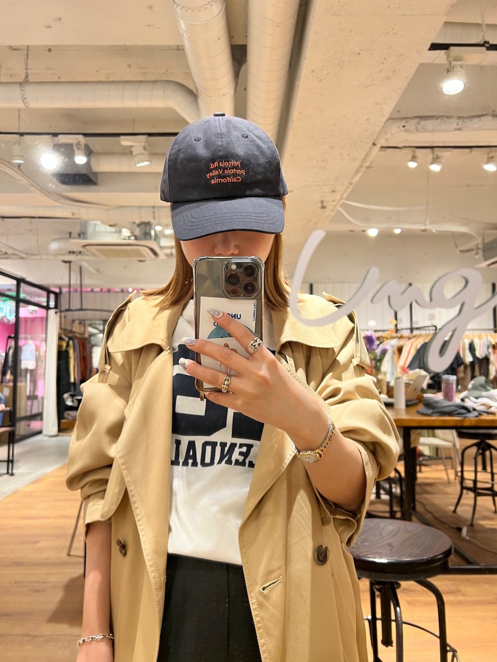 ホワイト系のTシャツ/カットソー、ベージュ系のトレンチコート、グレー系のキャップを着用したレディースの冬コーディネートの3枚目の写真