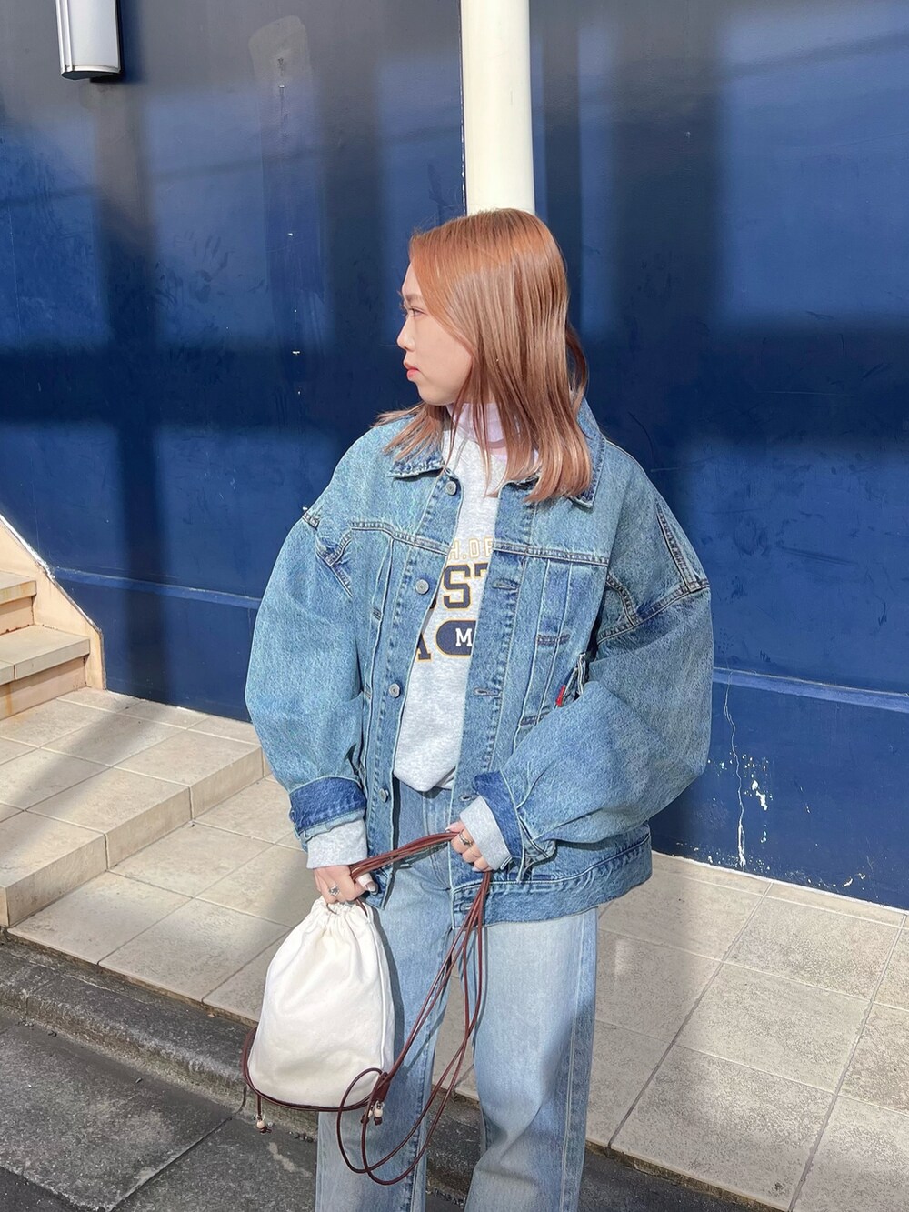 ブルー系のデニムジャケット、パープル系のTシャツ/カットソー、グレー系のスウェットを着用したレディースの冬コーディネートの2枚目の写真