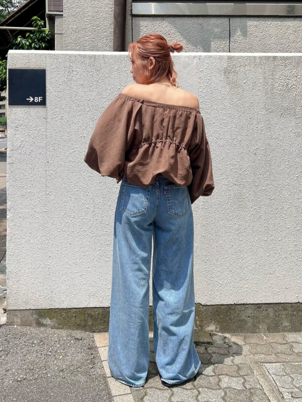 ブルー系のデニムパンツ、ブラウン系のシャツ/ブラウスを着用したレディースの夏コーディネートの3枚目の写真