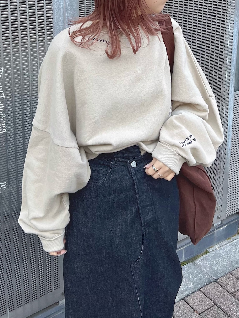 ベージュ系のスウェット、ホワイト系のスカートを着用したレディースの冬コーディネートの2枚目の写真