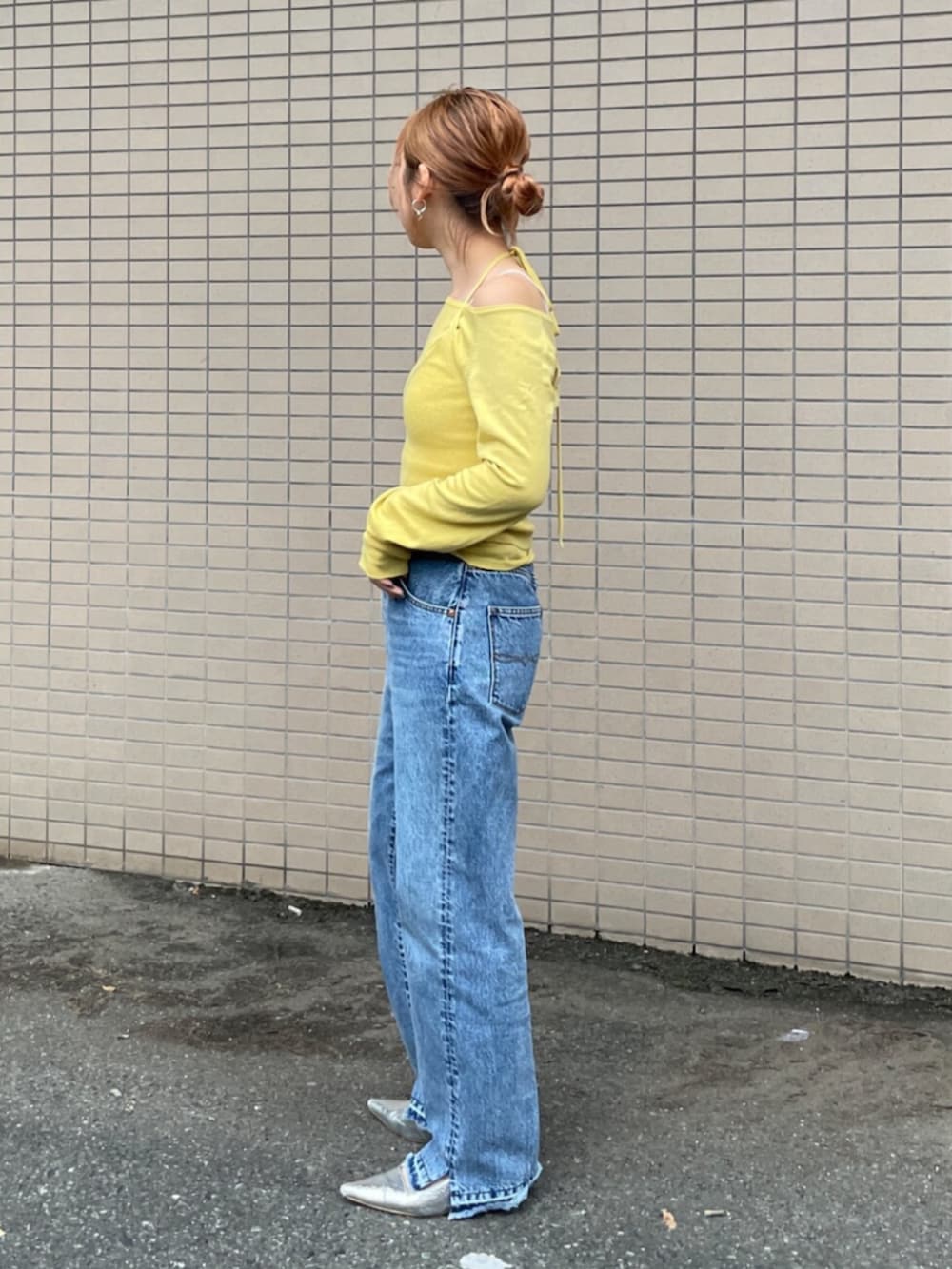 ブルー系のデニムパンツ、イエロー系のニット/セーターを着用したレディースの秋コーディネートの2枚目の写真