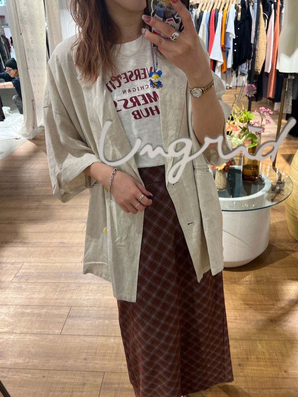 ホワイト系のテーラードジャケット、ホワイト系のTシャツ/カットソー、ブラウン系のスカートを着用したレディースの春コーディネートの2枚目の写真