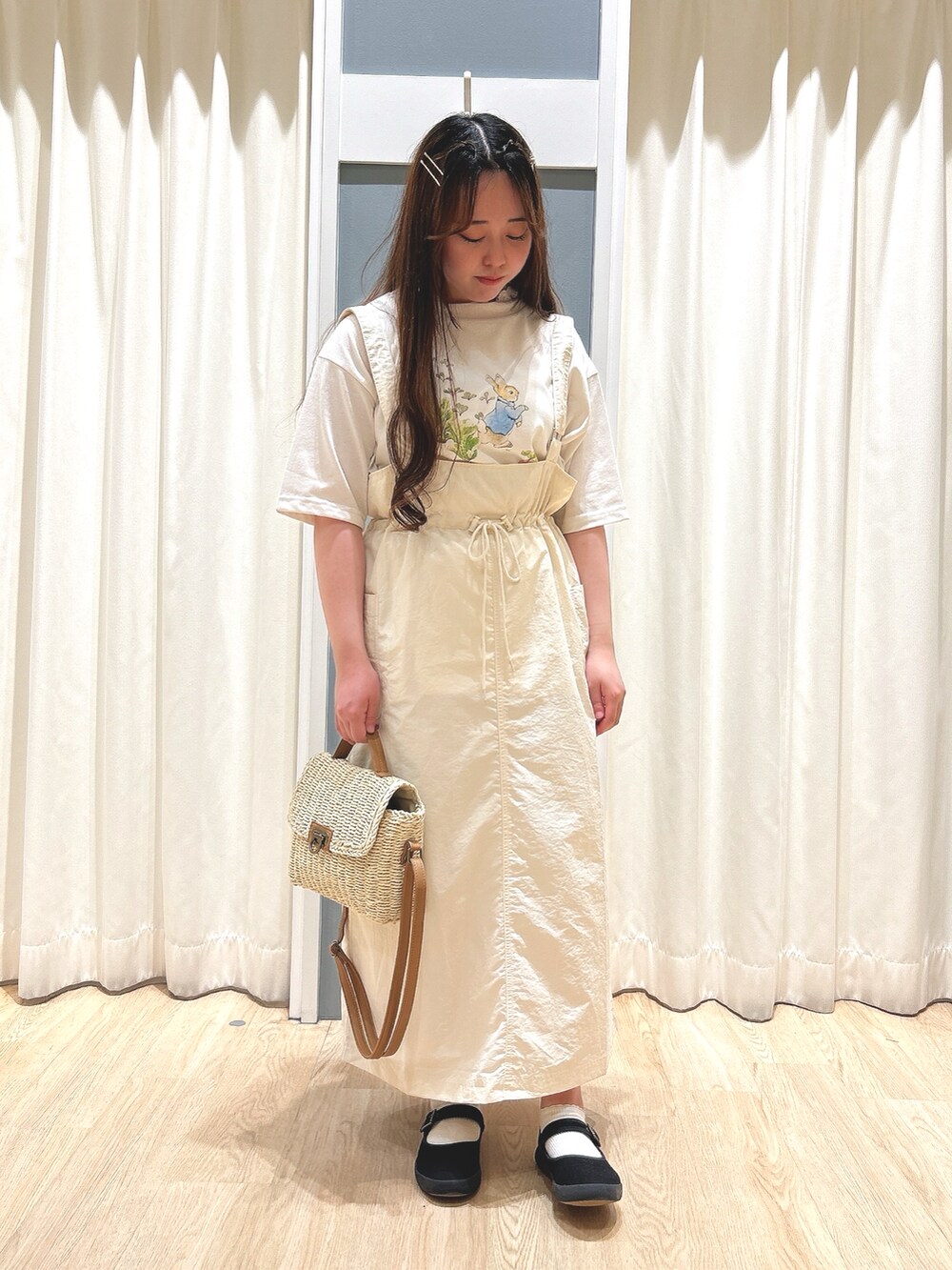 ホワイト系のスカート、ホワイト系のTシャツ/カットソー、ホワイト系のハンドバッグを着用したレディースの夏コーディネートの3枚目の写真
