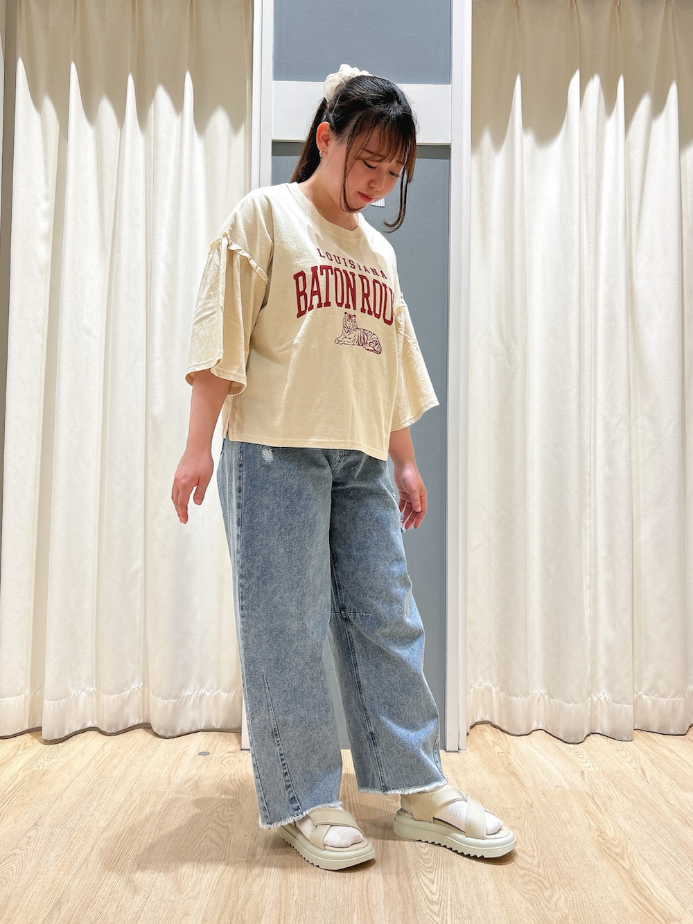 ブルー系のデニムパンツ、ホワイト系のハンドバッグ、ベージュ系のドレスシューズを着用したレディースの春コーディネートの4枚目の写真