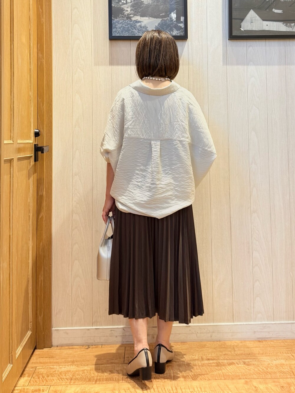 ベージュ系のシャツ/ブラウス、ブラック系のパンプス、ブラウン系のスカートを着用したレディースの秋コーディネートの3枚目の写真