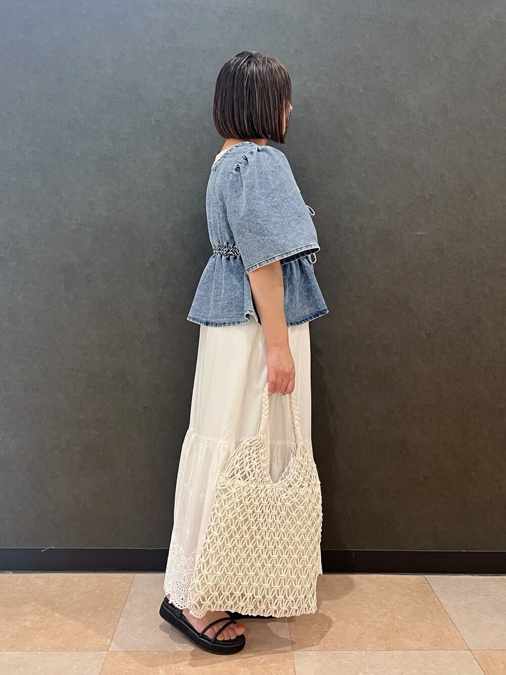 ホワイト系のタンクトップ、ブルー系のTシャツ/カットソー、ホワイト系のスカートを着用したレディースの夏コーディネートの2枚目の写真