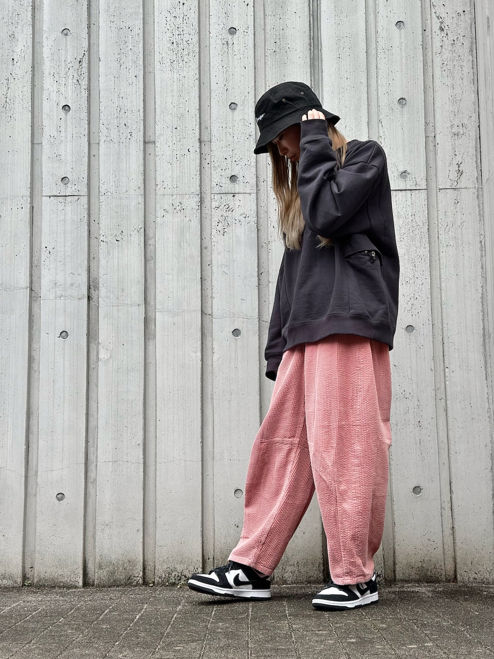 ブラック系のスウェット、ピンク系のその他パンツ、ホワイト系のスニーカーを着用したレディースの秋コーディネートの2枚目の写真