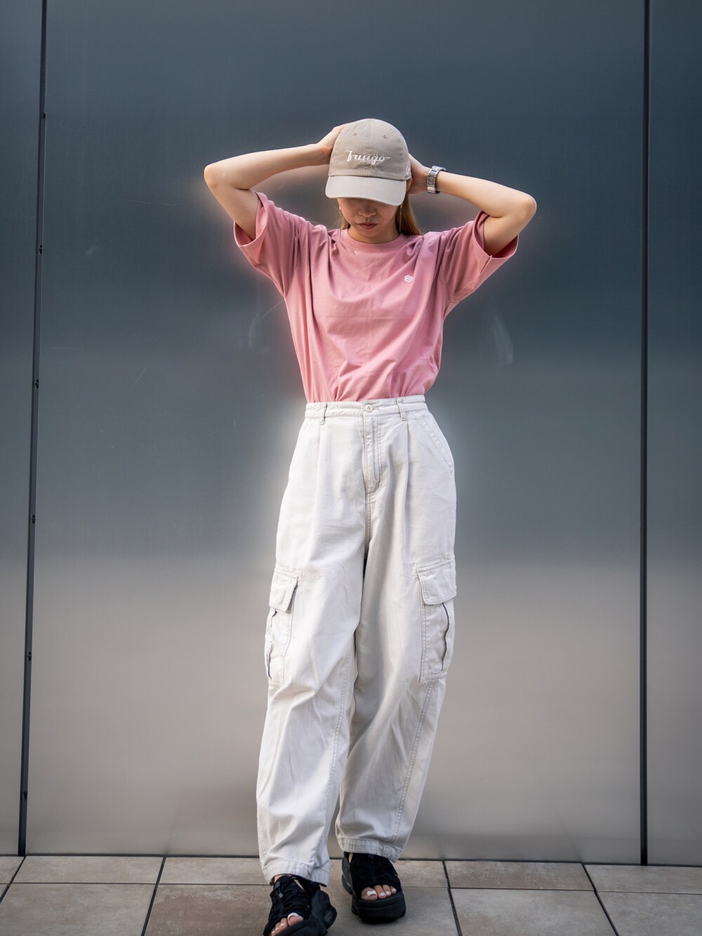 ベージュ系のカーゴパンツ、ブラック系のサンダル、ピンク系のTシャツ/カットソーを着用したレディースの秋コーディネートの2枚目の写真