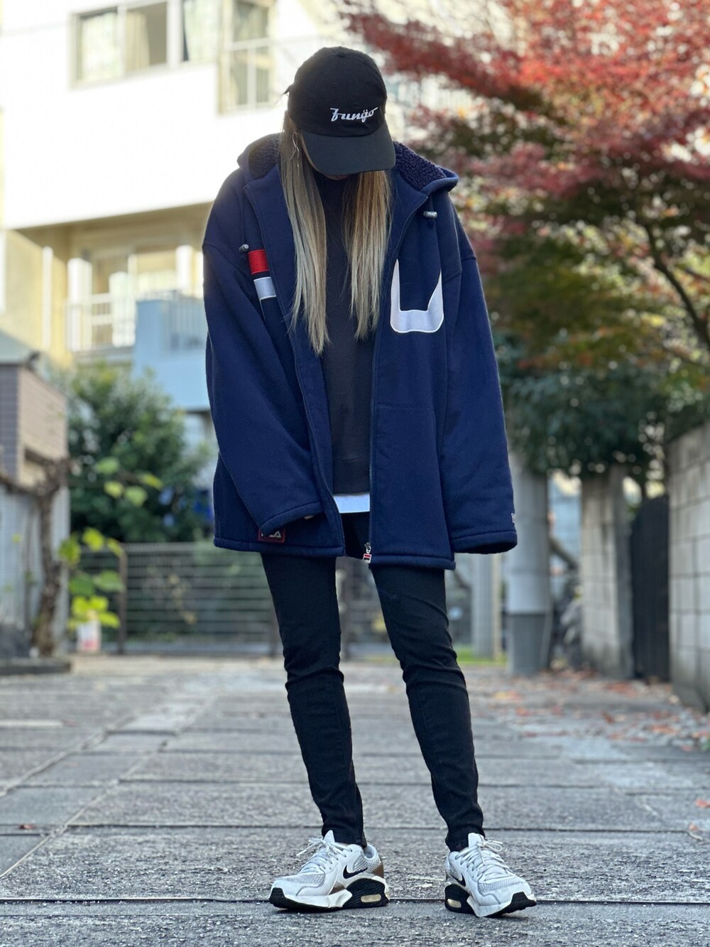 ブラック系のスウェット、ホワイト系のTシャツ/カットソー、ブラック系のデニムパンツを着用したレディースの冬コーディネートの2枚目の写真