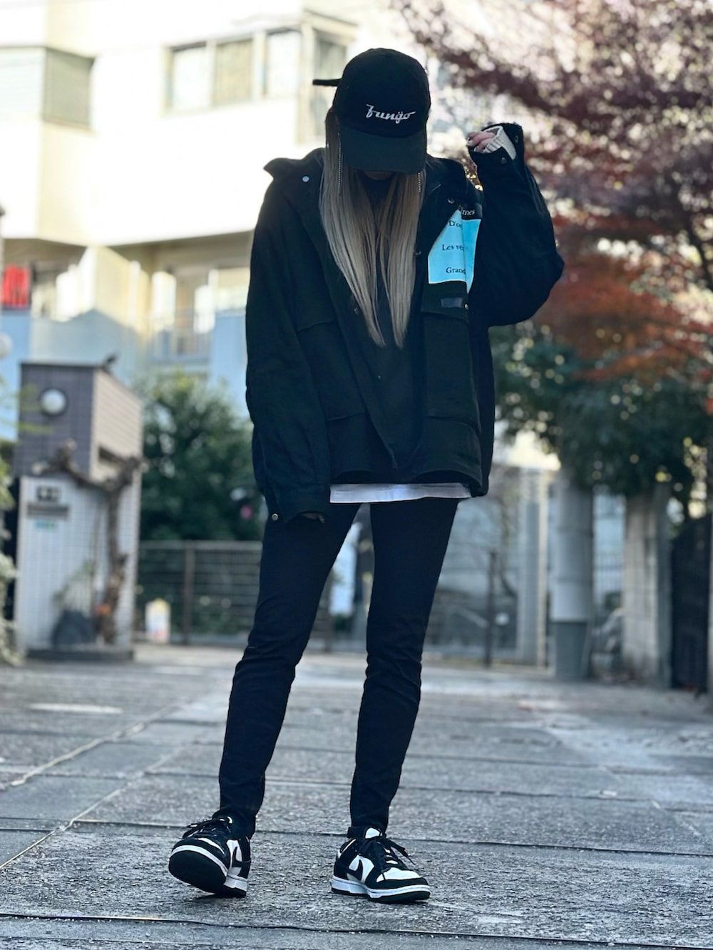 ホワイト系のスニーカー、ブラック系のデニムパンツ、ブラック系のジャケット/アウターを着用したレディースの冬コーディネートの2枚目の写真