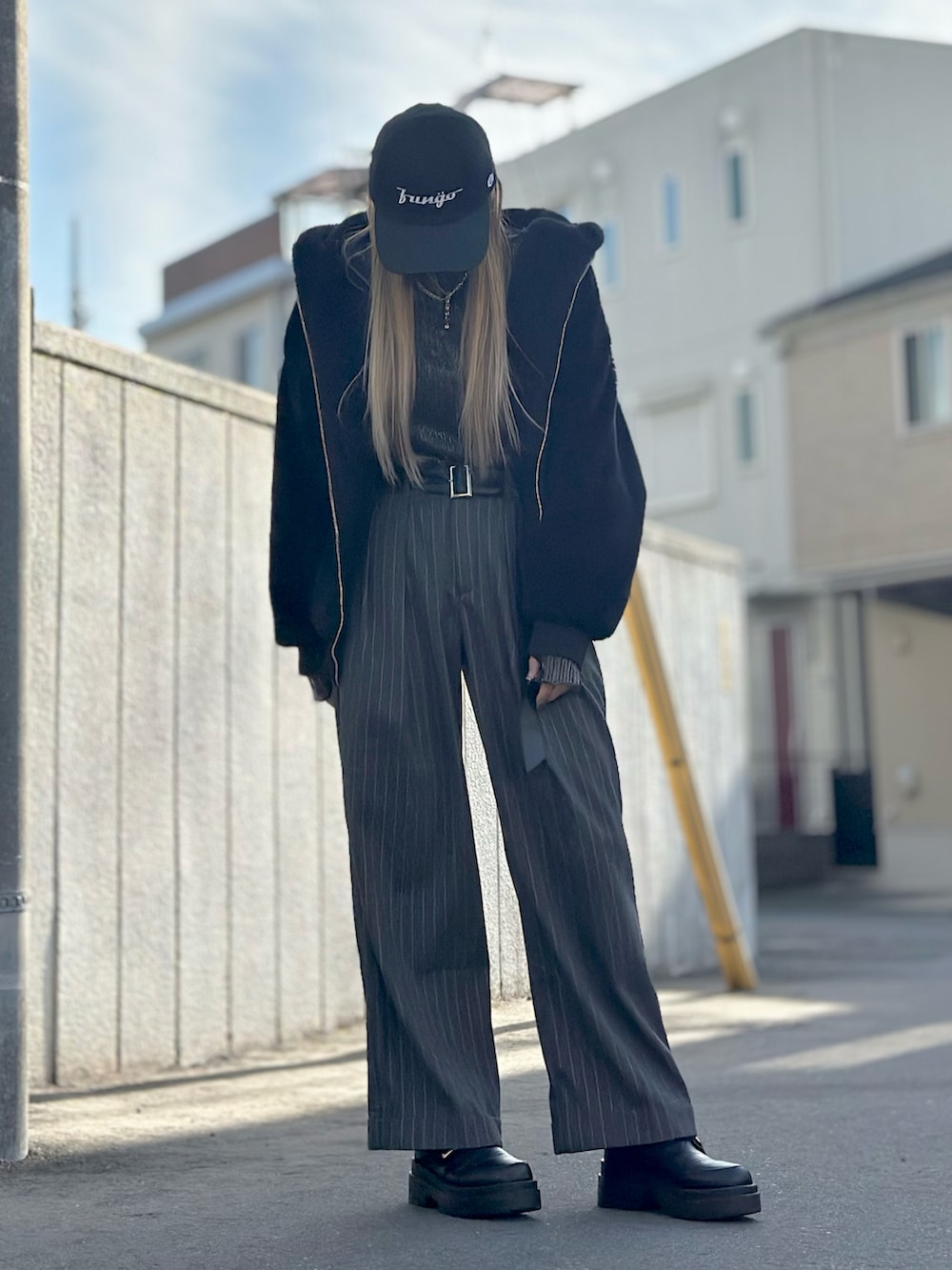 グレー系のパンツ、ブラック系のローファー、ブラック系のブルゾンを着用したレディースの冬コーディネートの5枚目の写真