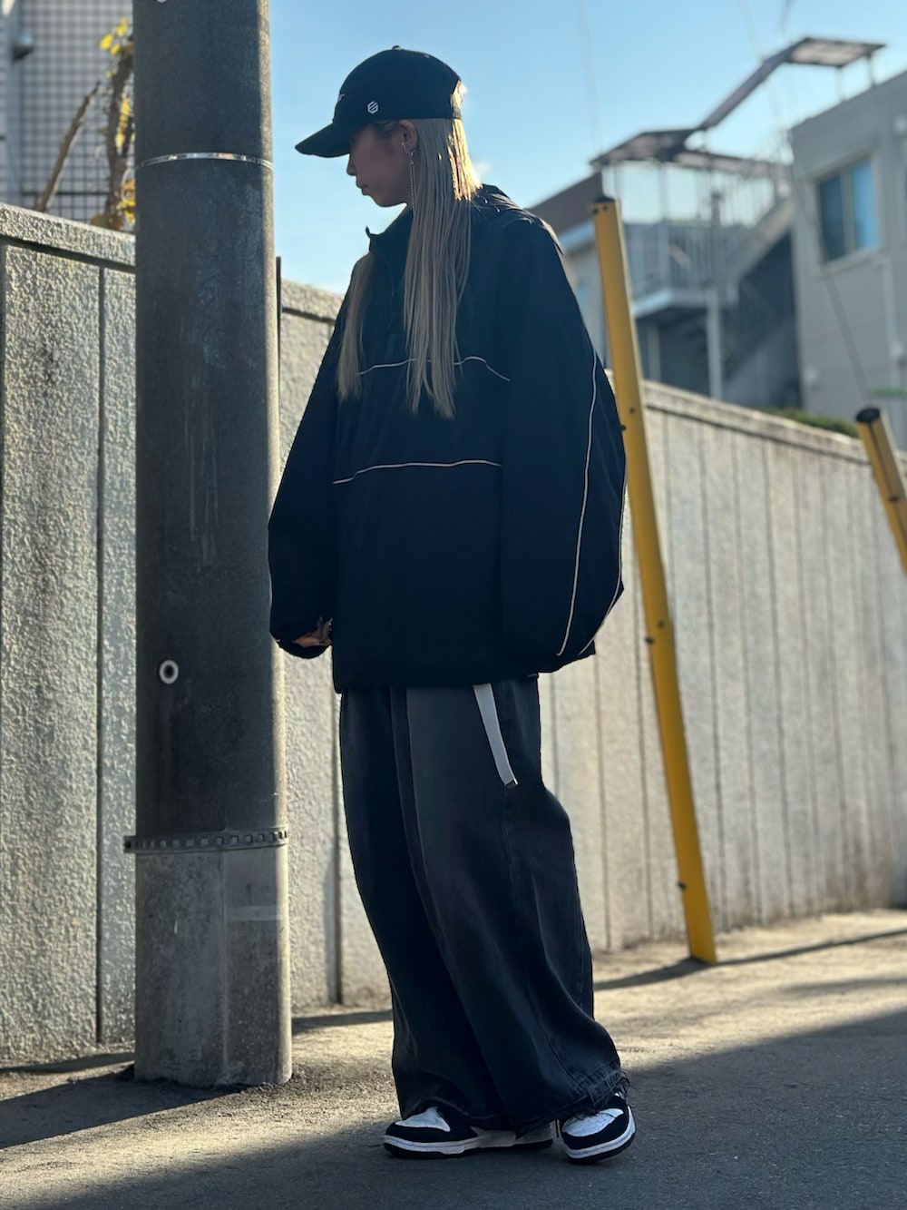 ブラック系のデニムパンツ、ホワイト系のスニーカー、ブラック系のトップスを着用したレディースの冬コーディネートの3枚目の写真