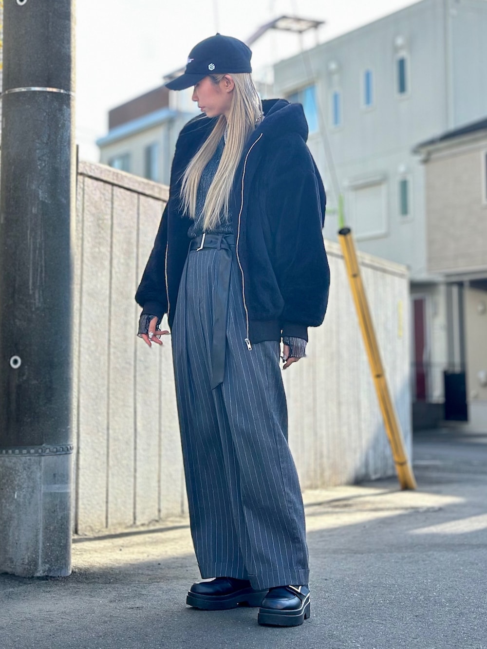 グレー系のパンツ、ブラック系のローファー、ブラック系のブルゾンを着用したレディースの冬コーディネートの2枚目の写真