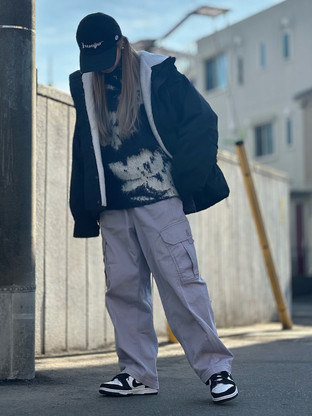 ブラック系のマウンテンパーカー、ブルー系のニット/セーター、パープル系のカーゴパンツを着用したレディースの冬コーディネートの3枚目の写真