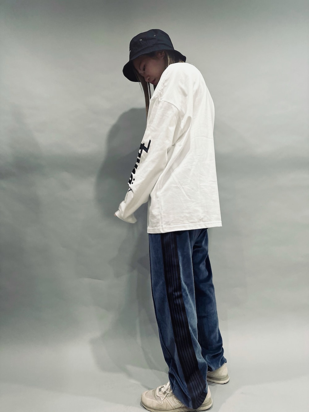 ブルー系のその他パンツ、ホワイト系のスニーカー、ホワイト系のTシャツ/カットソーを着用したレディースの秋コーディネートの2枚目の写真