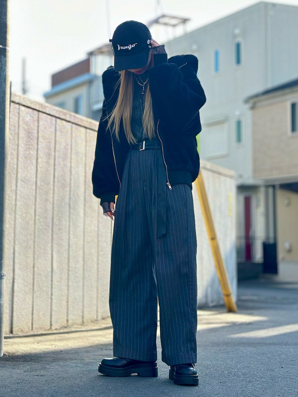 グレー系のパンツ、ブラック系のローファー、ブラック系のブルゾンを着用したレディースの冬コーディネートの3枚目の写真