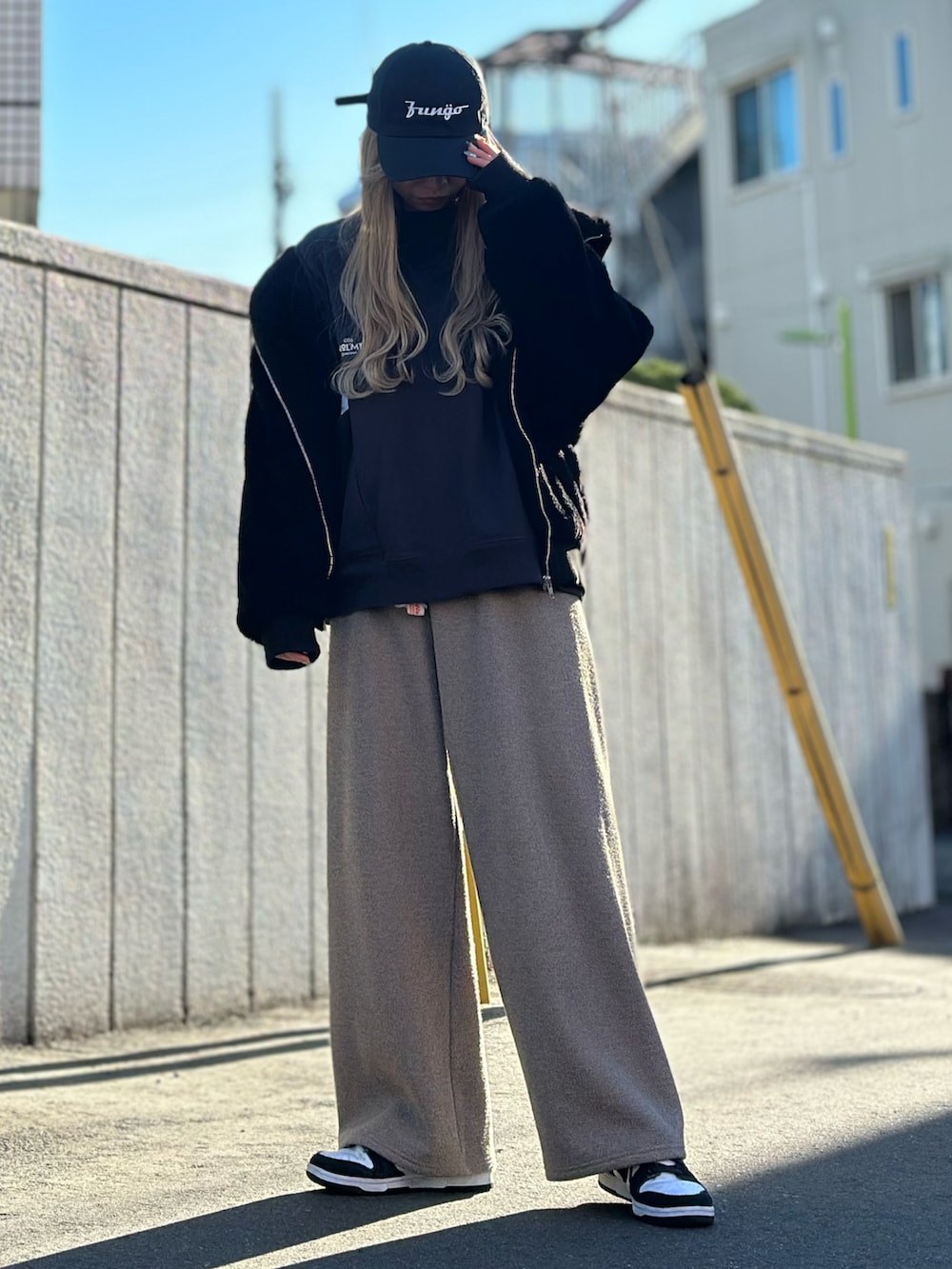 ブラック系のスウェット、ブラック系のブルゾン、ブラウン系のその他パンツを着用したレディースの冬コーディネートの2枚目の写真