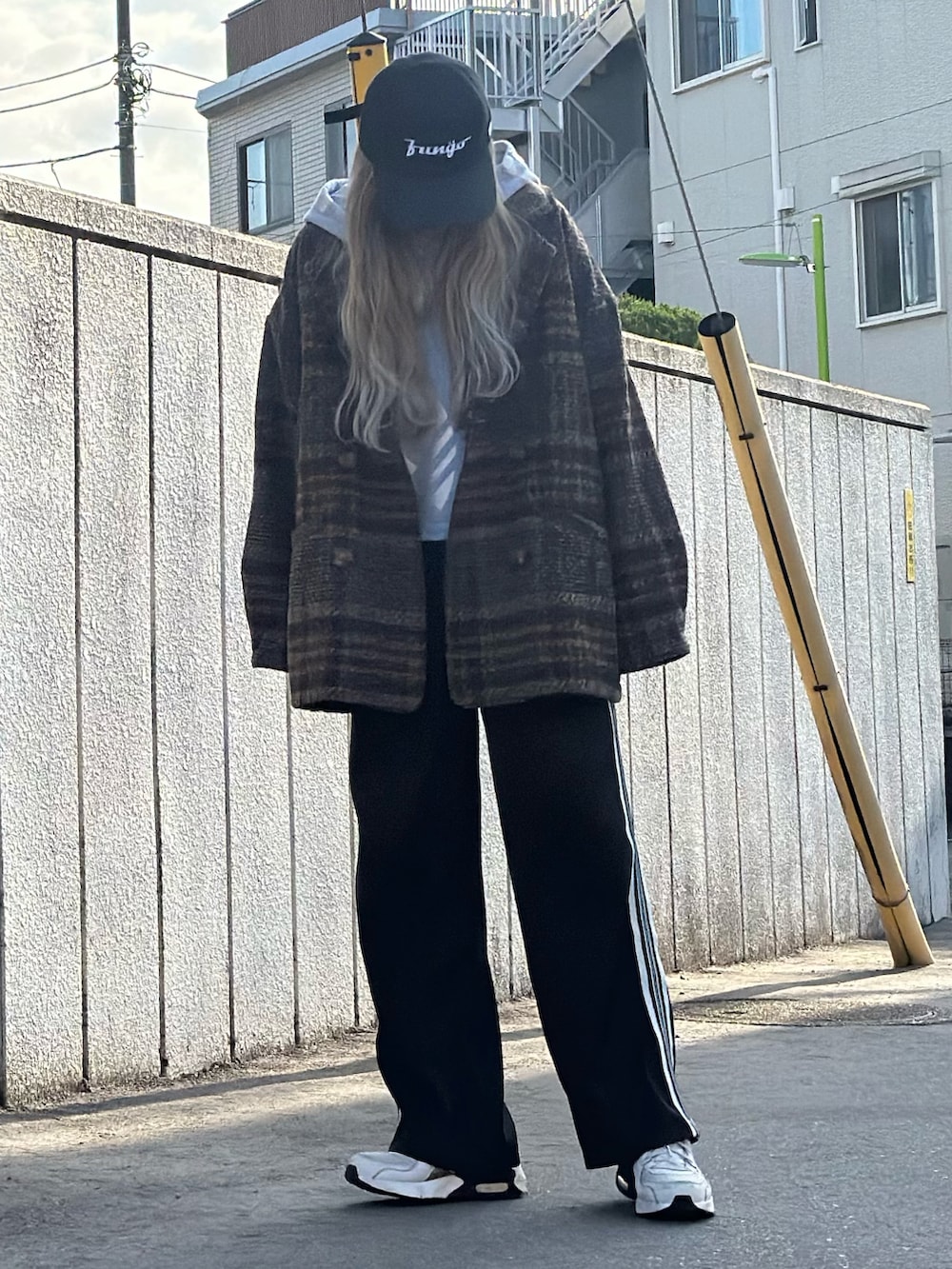 ブラック系のパンツ、ブラウン系のジャケット/アウター、ベージュ系のスニーカーを着用したレディースの冬コーディネートの2枚目の写真