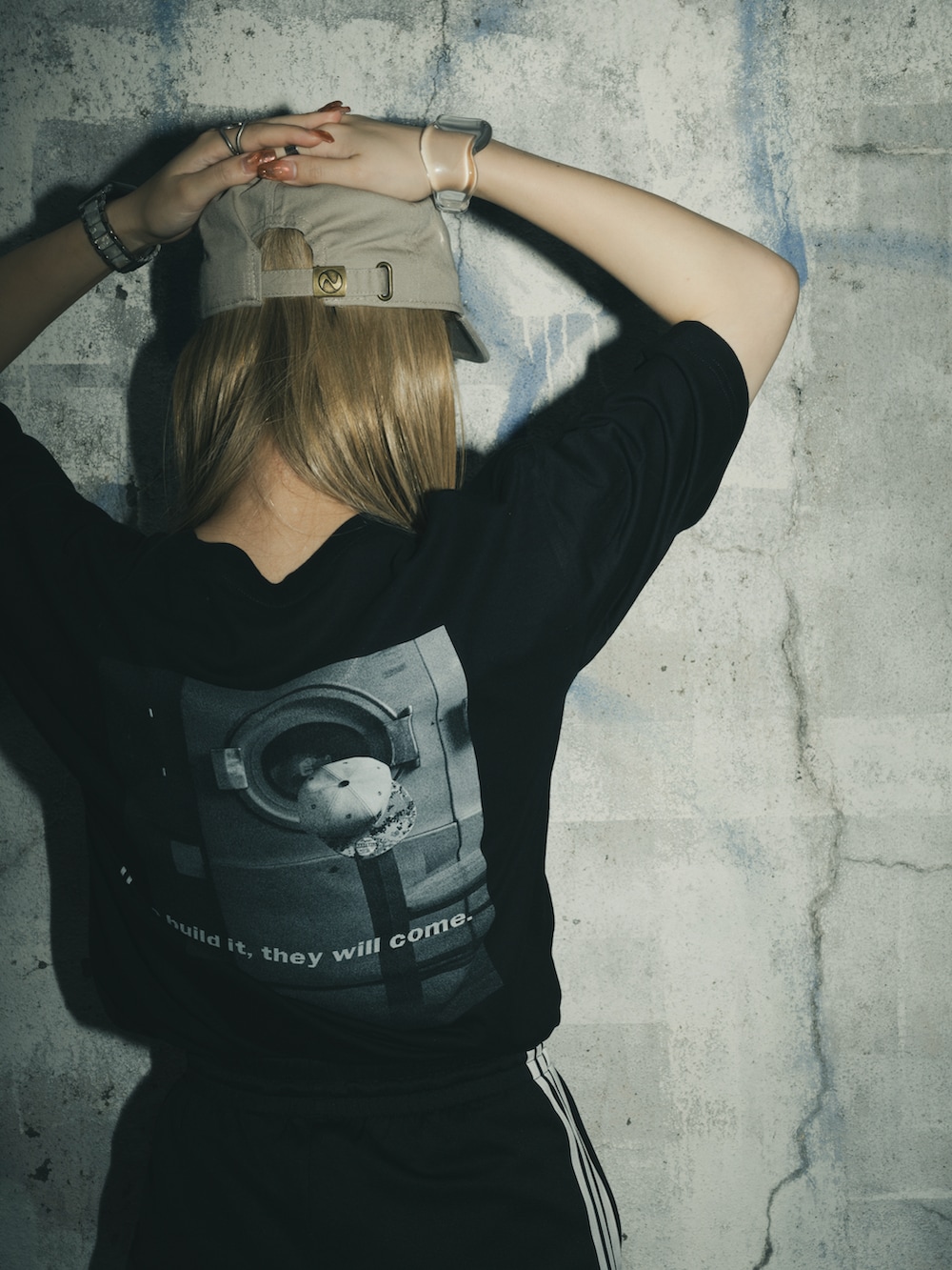 ブラック系のTシャツ/カットソー、ブラック系のその他パンツ、ベージュ系のキャップを着用したレディースの春コーディネートの2枚目の写真