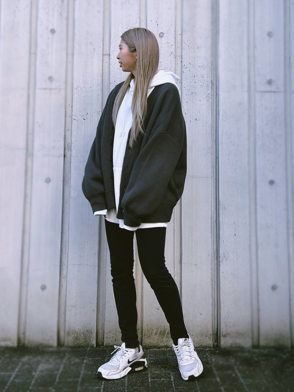 グレー系のカーディガン/ボレロ、ホワイト系のパーカー、ブラック系のデニムパンツを着用したレディースの冬コーディネートの2枚目の写真
