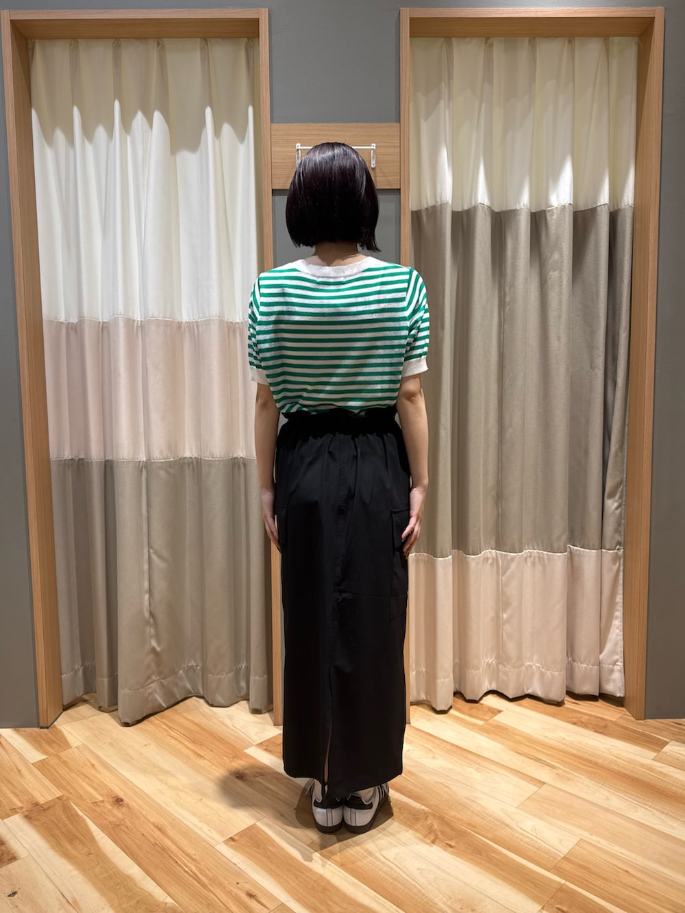 ブラック系のスカート、グリーン系のニット/セーターを着用したレディースの夏コーディネートの3枚目の写真