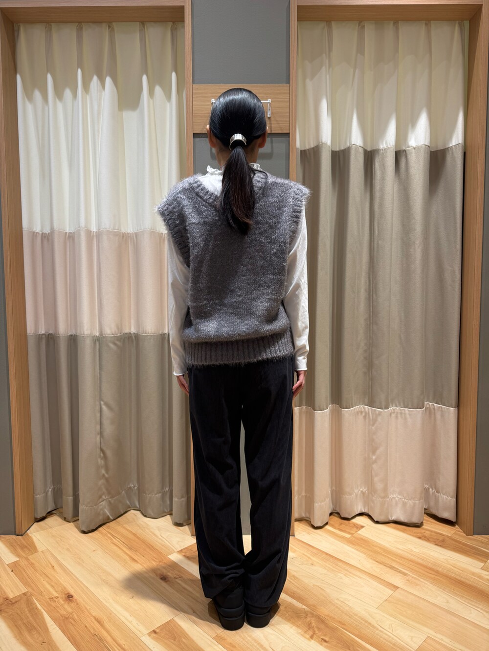 グレー系のパンツ、グレー系のトップス、ホワイト系のTシャツ/カットソーを着用したレディースの冬コーディネートの4枚目の写真