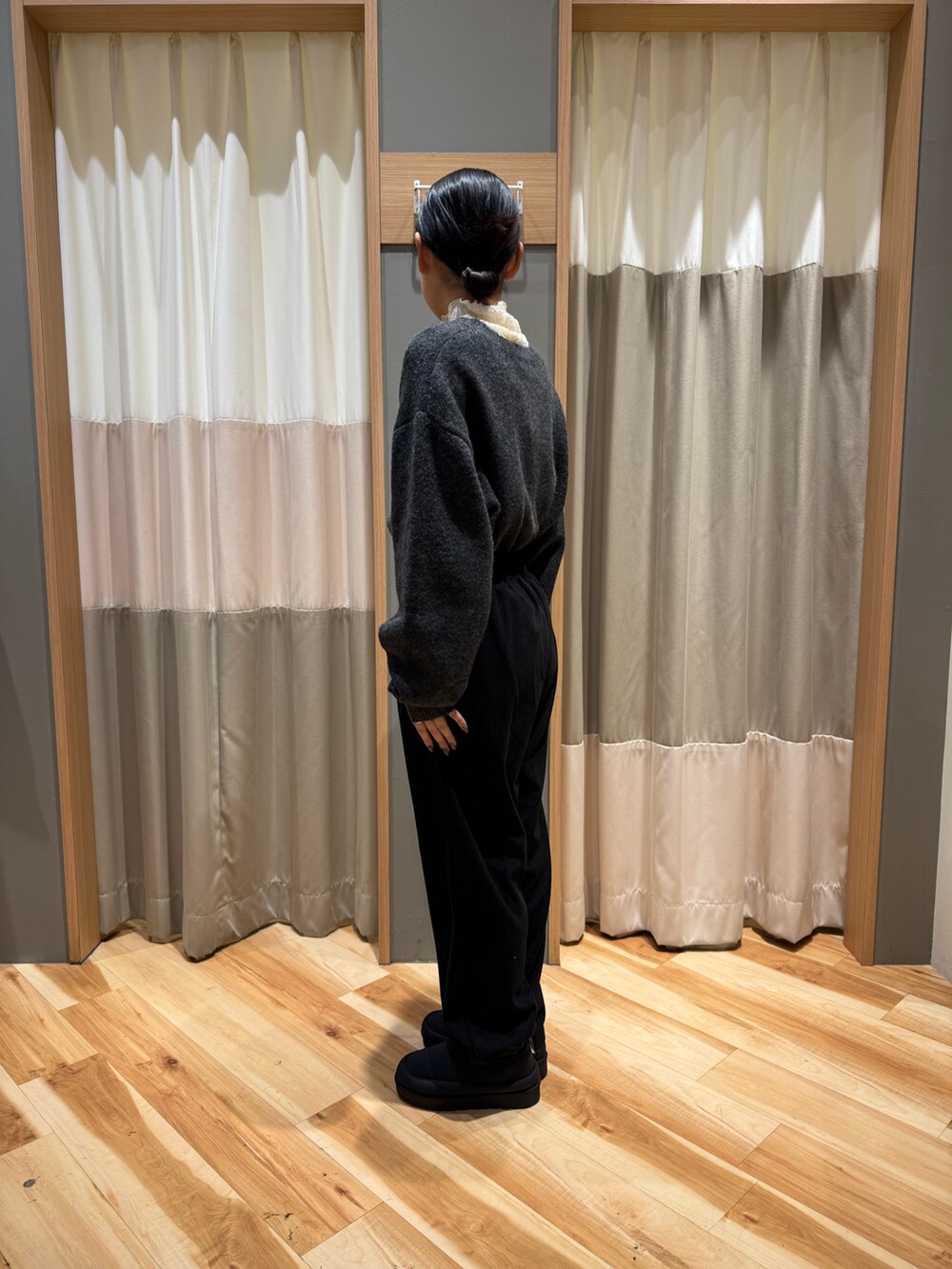 グレー系のニット/セーター、ホワイト系のTシャツ/カットソー、ブラック系のパンツを着用したレディースの冬コーディネートの2枚目の写真