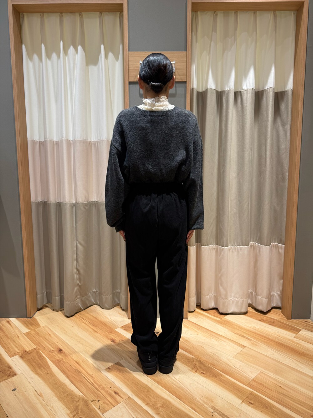 グレー系のニット/セーター、ホワイト系のTシャツ/カットソー、ブラック系のパンツを着用したレディースの冬コーディネートの3枚目の写真