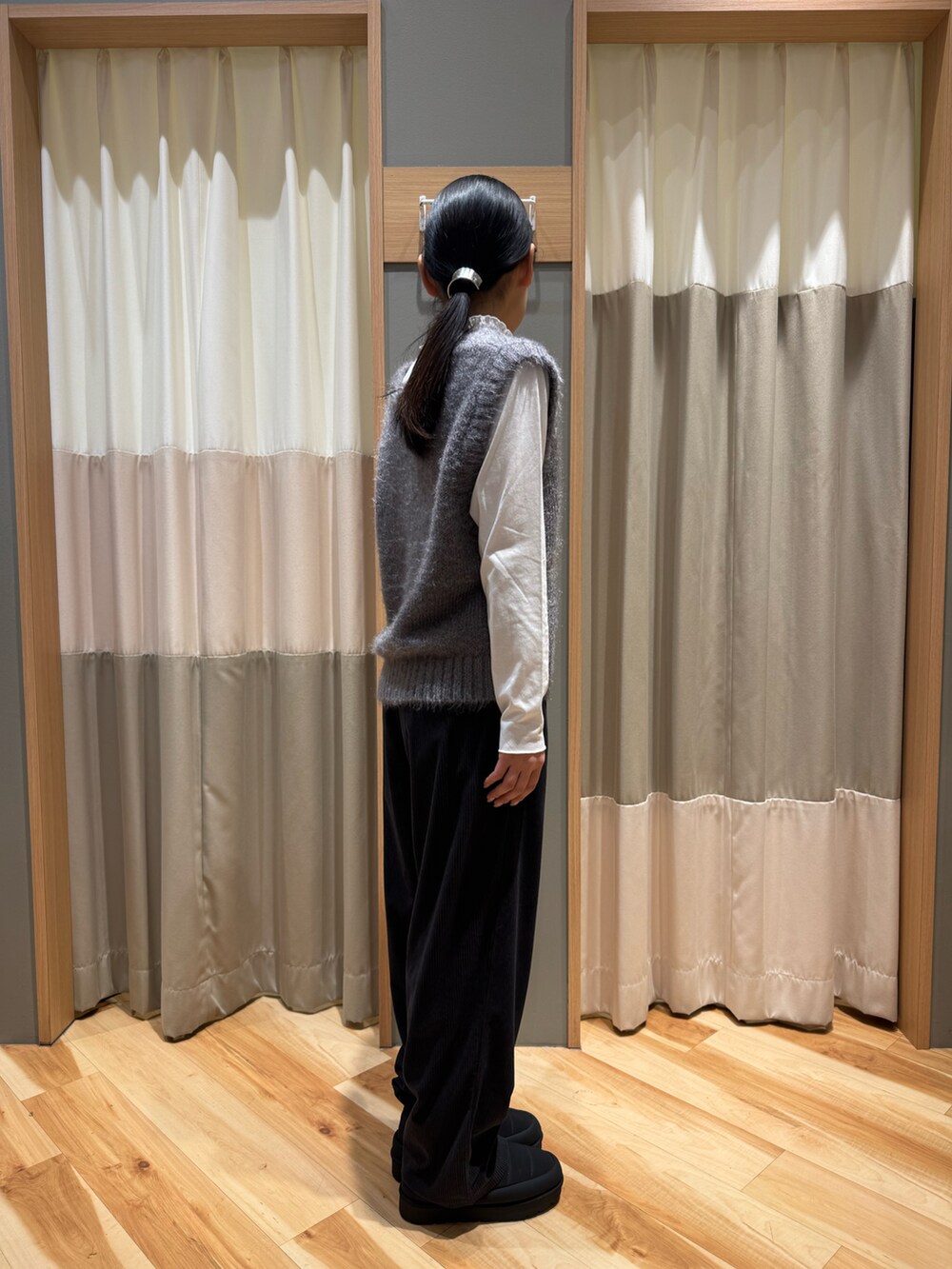 グレー系のパンツ、グレー系のトップス、ホワイト系のTシャツ/カットソーを着用したレディースの冬コーディネートの5枚目の写真